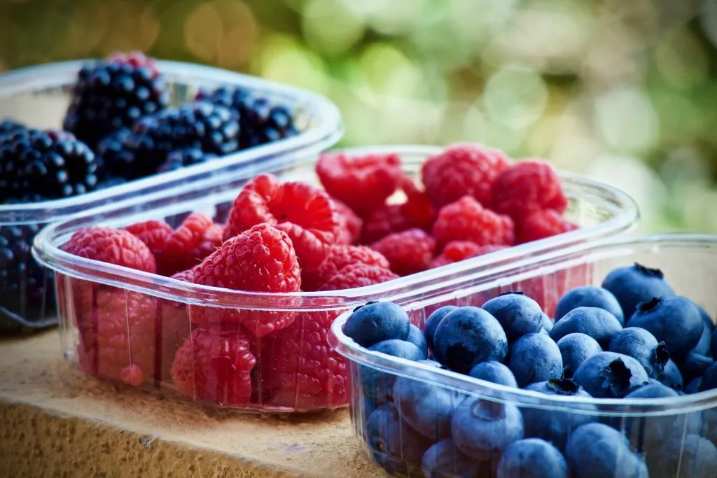 777970 - Doctor Pedro García Avolio - Recetitas.Com Assorted berries in clear plastic containers: raspberries, blueberries, and blackberries outdoors.